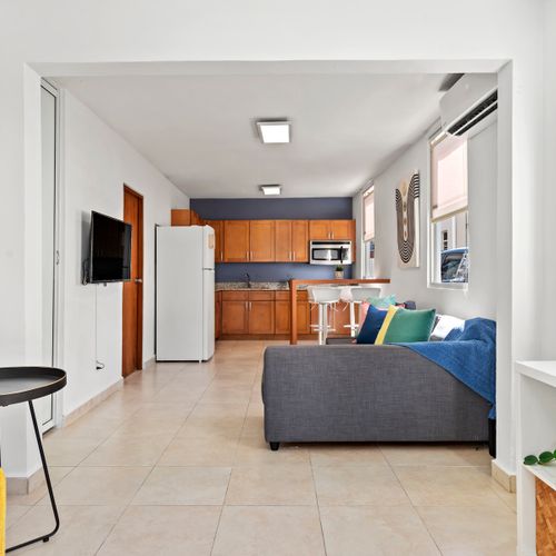 A chic and comfortable space. Our living room is designed for both style and function, with a TV for entertainment and a large mirror to open up the room.