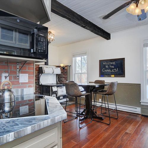 - sunny breakfast nook with tall windows, rustic leather bar chairs, and cozy vibes
- classic charm with exposed brick, antique stove, and chalkboard greeting sign
- great for casual meals, board games, or morning coffee catch ups