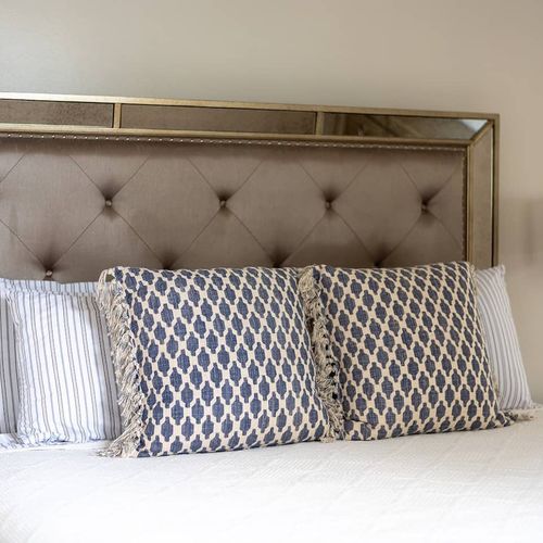 Close-up of the luxurious bed featuring a chic, mirrored headboard and stylish accent pillows. Every detail is designed for comfort and elegance, providing a restful and inviting retreat.