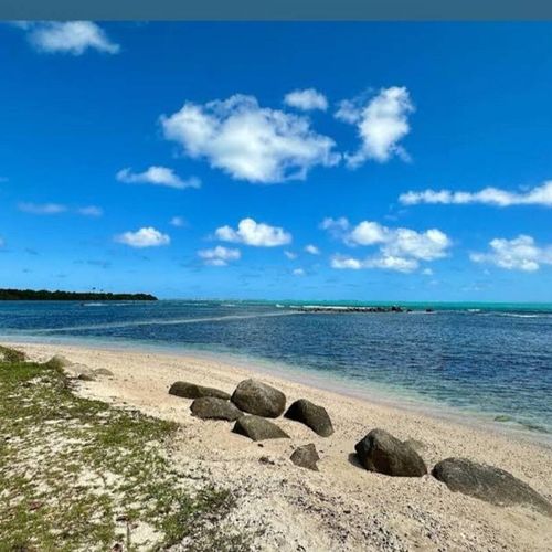 Experience pure tranquility on this stunning beach. Crystal-clear waters meet soft sand, with a mesmerizing horizon under a vibrant blue sky.