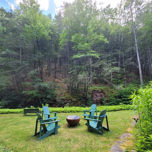 Kick back at the new firepit and Adirondack chairs with view of  the creek .