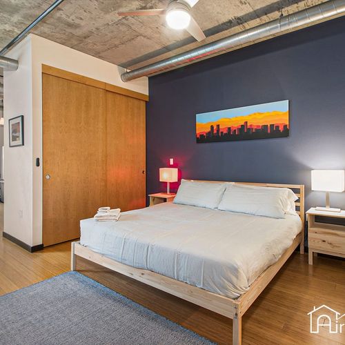 - sleep peacefully in a king size bed framed by a cityscape mural and deep blue wall
- wood floors and sliding closet doors add warmth to the minimalist design
- subtle lighting and modern furnishings create a cozy and stylish retreat