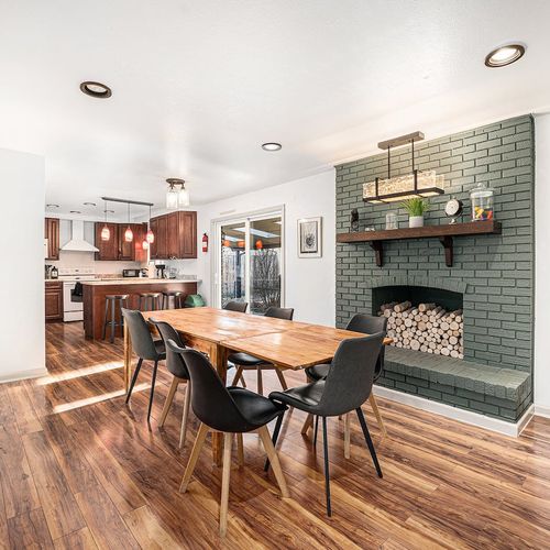 - bright and welcoming dining area with warm wood tones and a playful modern hearth
- gather for meals or game nights just steps from the fully equipped kitchen
- easy patio access and bar seating make this the heart of your stay