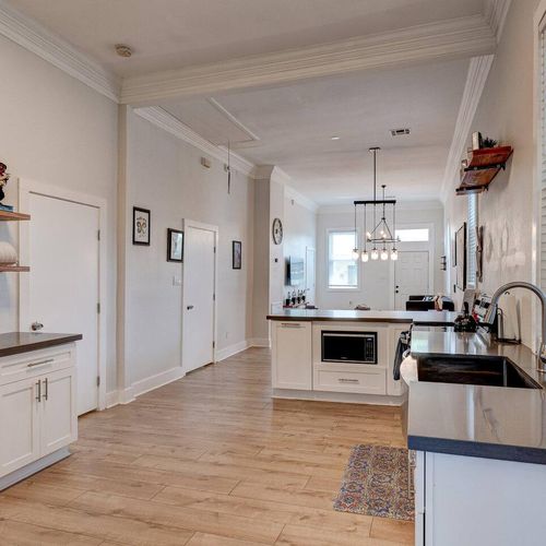 Bright kitchen w/ pendant lighting, modern sink & stainless appliances — ready for home-cooked meals.