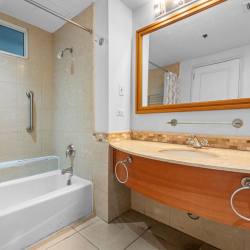 Enjoy the convenience of this bright and clean bathroom, featuring a refreshing shower and a relaxing bathtub.