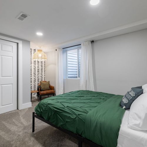 - relax in this plush bed dressed in rich green tones and soft white pillows
- stylish woven pendant lamp lights up a quiet corner chair for reading or daydreaming
- bold wallpaper and neutral walls strike the perfect balance of cozy and modern