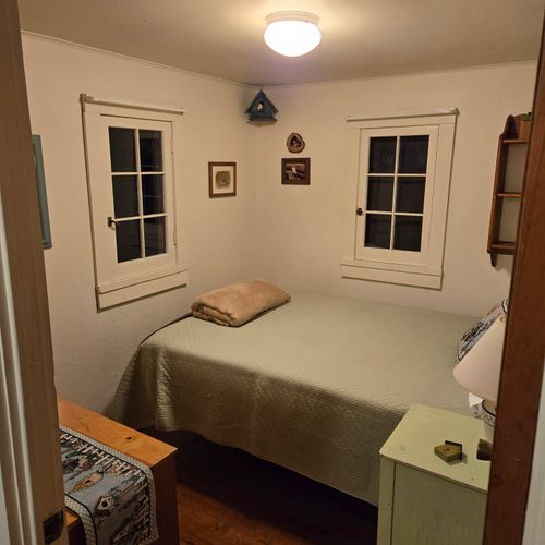 Bedroom #1:  features a full-size bed, nightstand, lamp, and dresser.