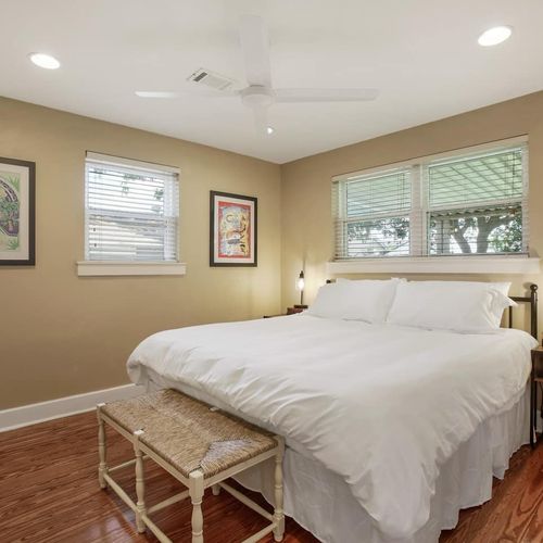 Drift off to sleep in this peaceful bedroom, featuring a comfortable king-sized bed and thoughtful decor. The warm tones and soft lighting create a restful ambiance, perfect for unwinding after a day of exploring New Orleans.