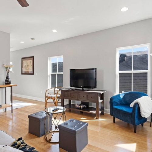 Open living space w/ a TV, blue accent chair & plenty of room to spread out.
