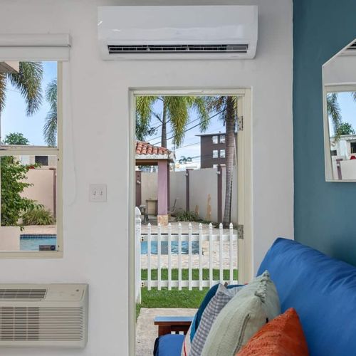 Bask in the natural light from large windows offering serene views of lush palms, ensuring a bright and inviting stay.