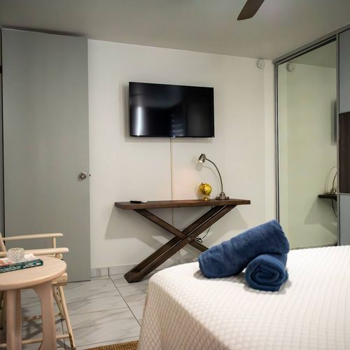 Enjoy a comfortable stay in this well-equipped room! Relax with a mounted flat-screen TV, a practical desk area, and a large sliding closet for all your belongings.