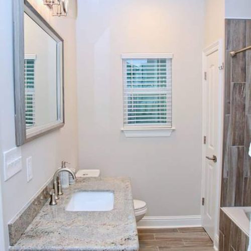 Bright, clean second hall bathroom w/ a sink & vanity mirror.