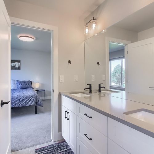 - dual sink vanity connects to the queen bedroom in a smart and efficient layout
- black fixtures and white cabinetry create a crisp, modern finish
- ideal for couples or families sharing the space during their stay