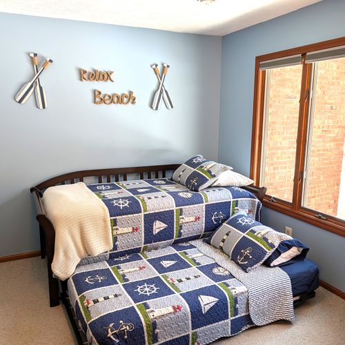 BEDROOM #1 (FIRST FLOOR):  There is a small bedroom with a trundle bed on the first floor.  Includes a closet, dresser, and mirror as well.