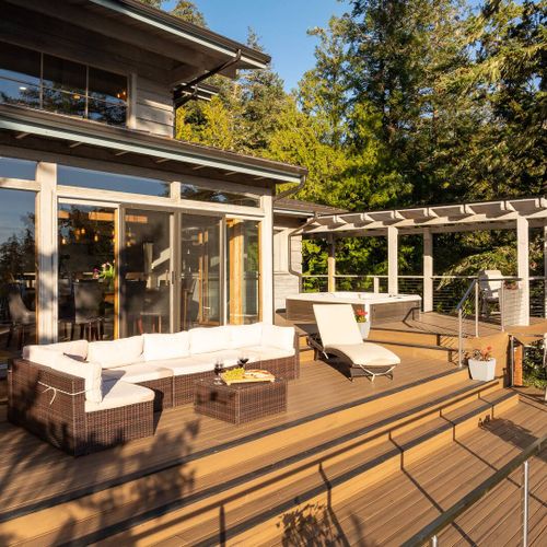 Outdoor patio with seating and hot tub with an overlook view of Grindstone Harbor