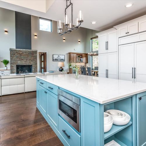 - bold blue island anchors this dream kitchen with prep space and open shelving
- built in microwave and sleek surfaces make meals easy and enjoyable
- enjoy seamless sightlines to the fireplace and dining area while you cook