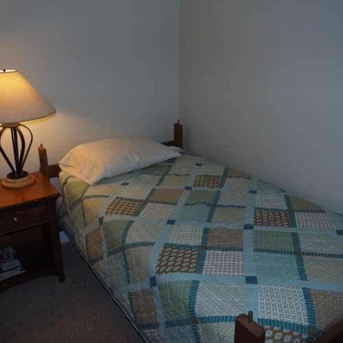 Bedroom #2:  features two twin beds, a nightstand, lamp, dresser, mirror, and closet.