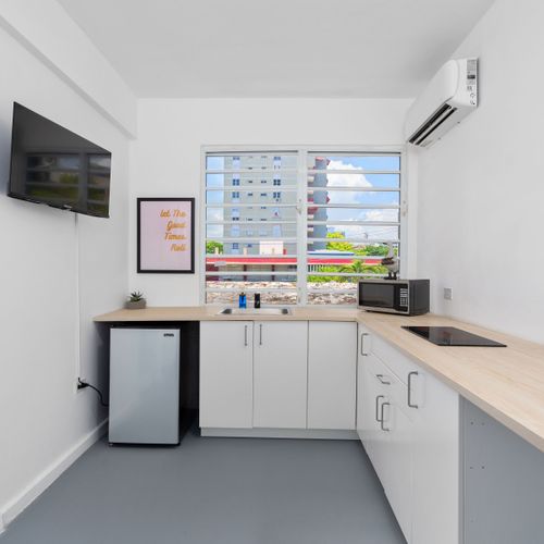 Amidst the modern design, an abstract painting adds a pop of color and artistic flair to this cozy kitchen space.