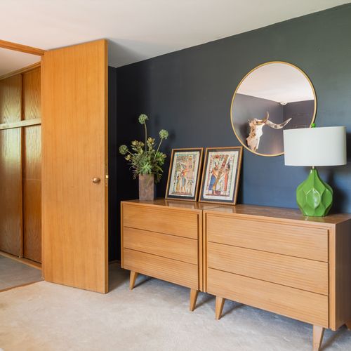Storage space across the bed, topped with Egyptian art.