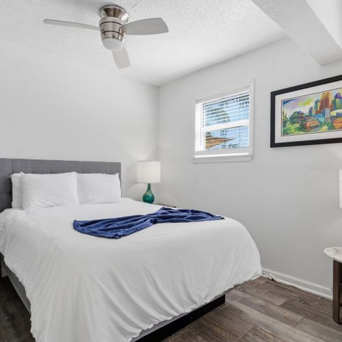 Sun-filled bedroom w/ crisp white bedding & a relaxed, airy feel.