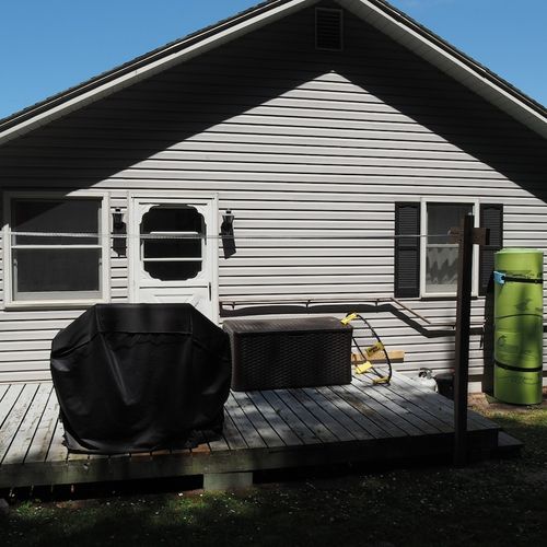 Exterior:  the back of the cottage, which includes a small deck, gas grill, and water toys, including a kayak and lillypad!