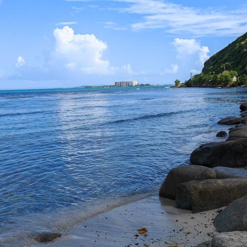 Discover the rugged charm of the Malolos coastline! This scenic beach offers a blend of sandy shores, natural rocks, and a tranquil blue sea, with distant views of the town.
