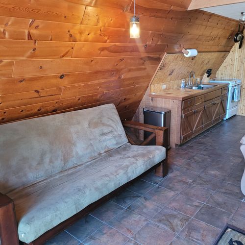 Living room:  features a sofa, futon, and a large television with cable television.