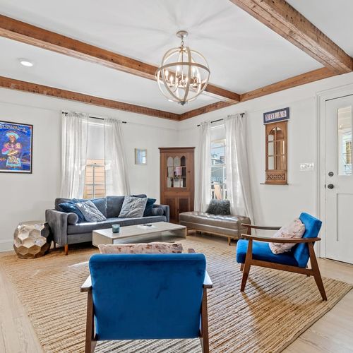 Bright living room w/ New Orleans-inspired decor & cozy blue seating.