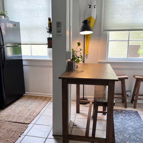 Dining area w/ a wooden table & pendant lighting for shared meals.