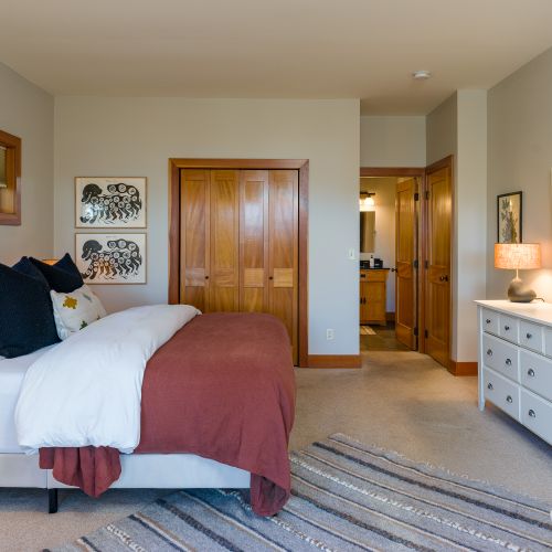 main bedroom with bedside table & Lamp, vanity mirror, and spacious closet for a comfortable, organized stay.