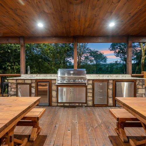 Built-in outdoor kitchen with sink, gas grill, ice maker, and mini fridge