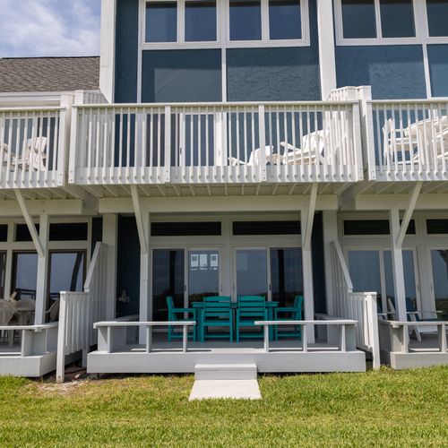 Modern beach architecture shines in whites and glass, open to coastal breeze.