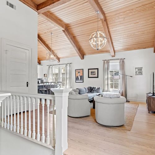 Spacious living room w/ vaulted wood ceilings & natural light.