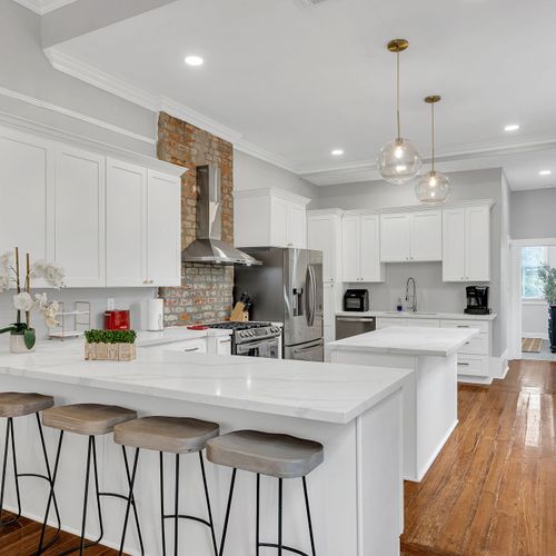 Bright and open living area with a stylish sectional and sleek kitchen, perfect for relaxing and entertaining.