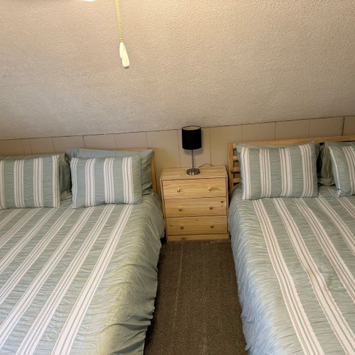 Bedroom #3 (upstairs):  features two queen beds, a ceiling fan, a nightstand, a lamp, and 2 large closets.