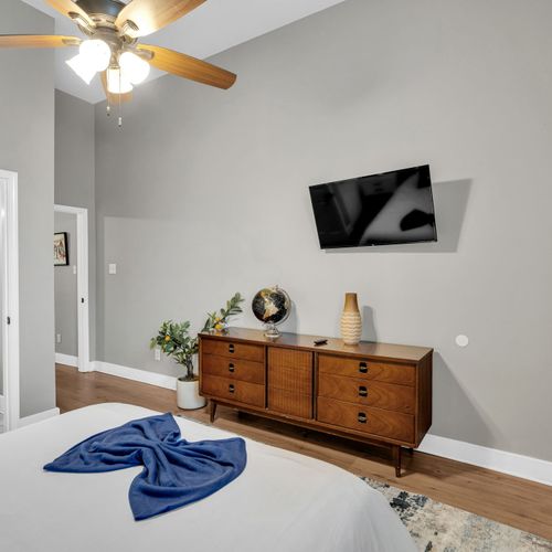 Bedroom w/ smart TV & wood dresser — everything you need for a comfortable stay.