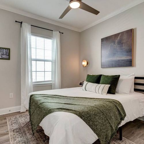 Calm bedroom w/ soft green accents & warm, inviting lighting.