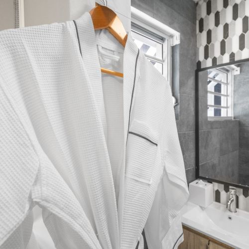 Pamper yourself in this elegant bathroom featuring a stylish vanity and fancy robe