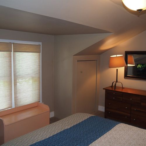 Bedroom #1:  features a queen-size bed, mirror, nightstands, lamps, dresser, chair, and television.