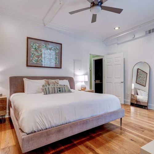 Spacious master bedroom w/ a king bed & warm, inviting decor.