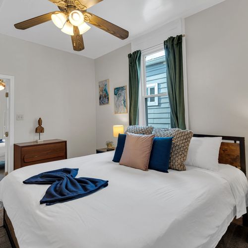 Warm bedroom w/ layered bedding & soft natural light for an easy, restful night.
