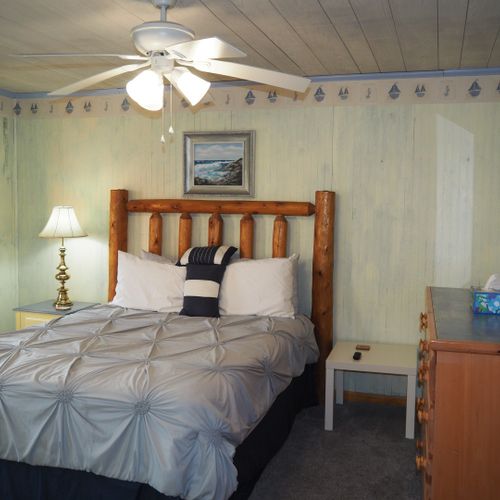 Bedroom #1 (main floor):  features a queen-size bed, private television, dresser, ceiling fan, closet, and en suite private bathroom.