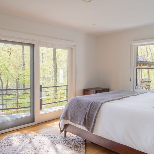 Stepping into the first of the main floor bedrooms, with access to the sprawling deck.