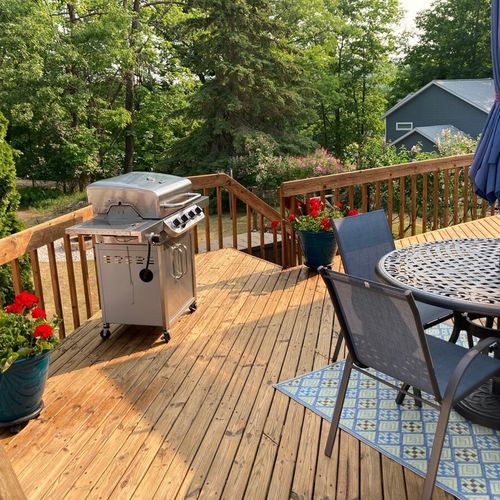 Exterior:  the large deck, featuring a propane grill and outdoor dining furniture.