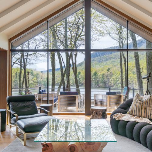 Massive windows in the living room reveal breathtaking views of the Shawangunks and private lake below.