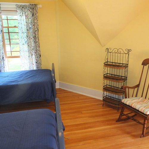 Bedroom #4 (second floor):  this very cute upstairs bedroom features two twin-size beds, a nightstand, lamp, pedestal fan, chair, and a large walk-in closet.
