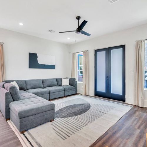 Kick back in the airy living room w/ a plush sectional and cool-toned decor.