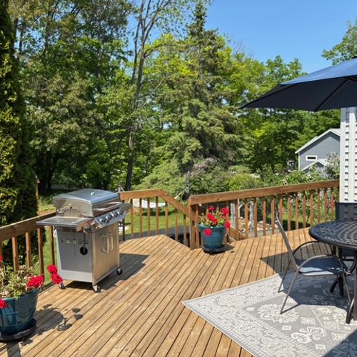 EXTERIOR:  The large deck, featuring a propane grill and outdoor dining furniture.