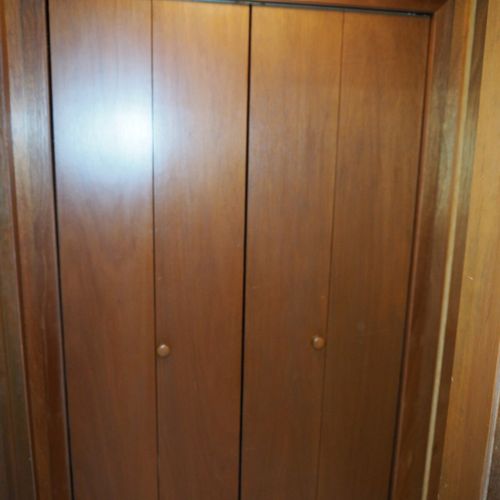 Hallway:  large storage closet at end of hallway with a vacuum cleaning, high chair, and laundry basket.
