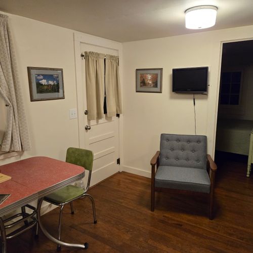 Living room:  the cabin has a cute little living room with a loveseat, dining table, and streaming television.